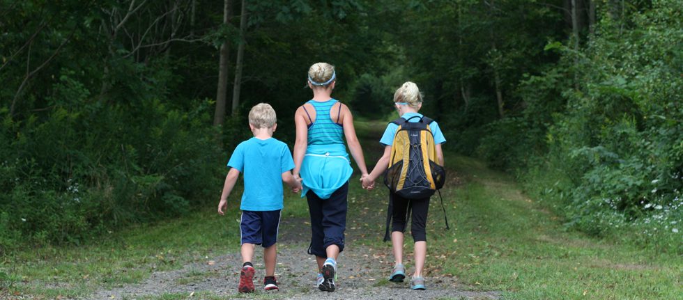 3 children hiking holding hands